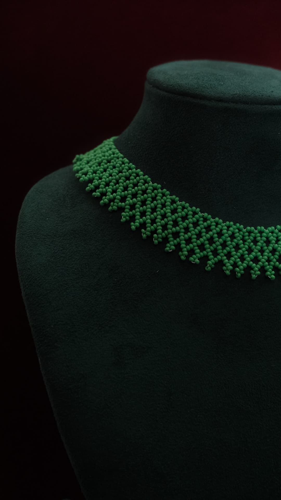 A wide woven net collar in emerald