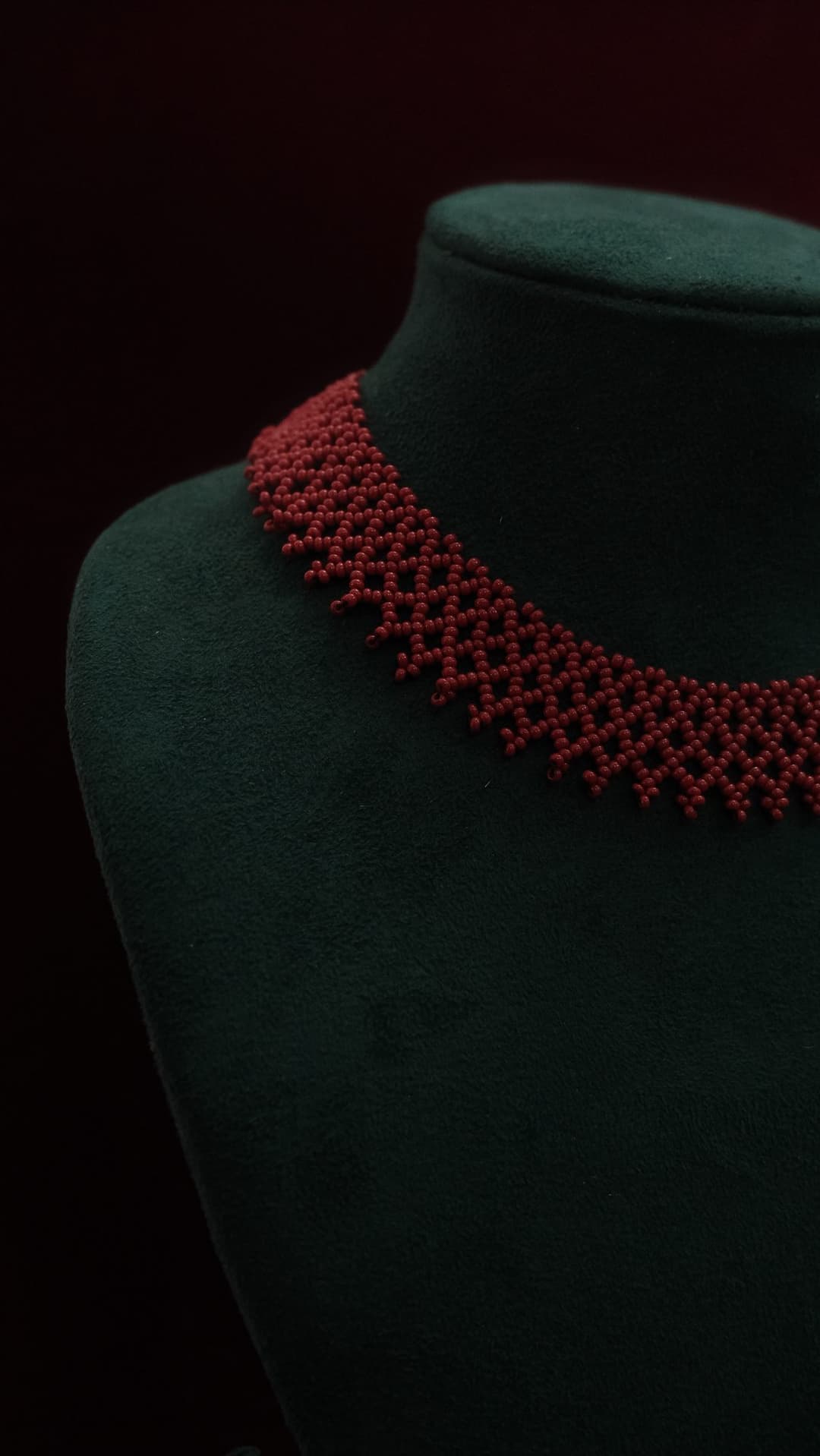 A wide woven net collar in ruby